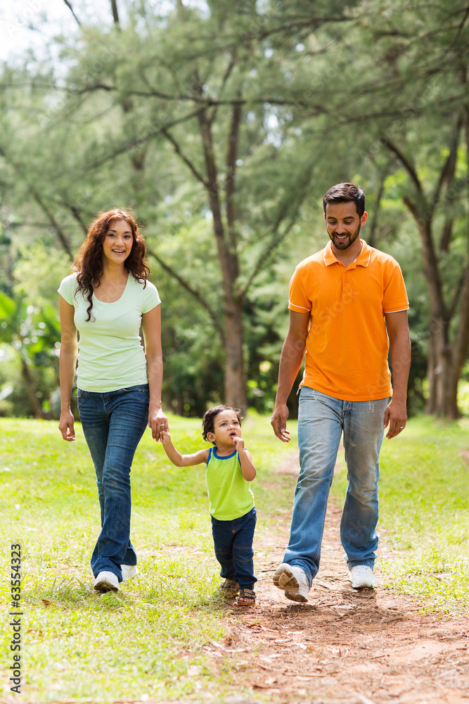 young indian family walking in park young indian family walking in park