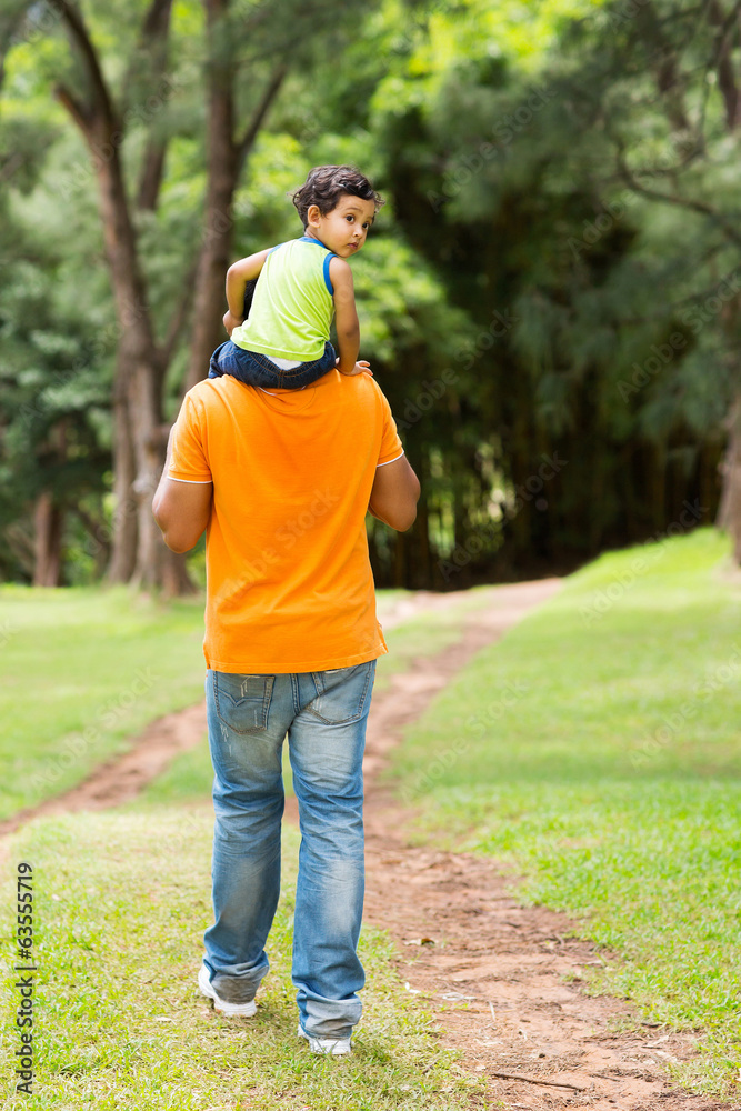cute little boy sitting on father's shoulders cute little boy sitting on father's shoulders