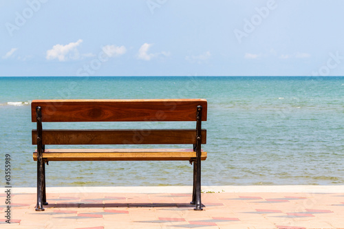 Blue sea,long wood chairs at the tropical beach on blue sky. © amnach