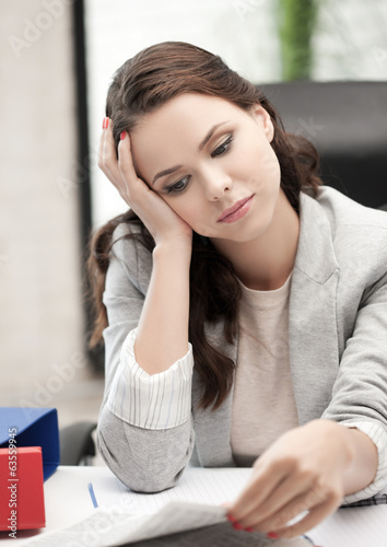 bored and tired woman behid the table photo