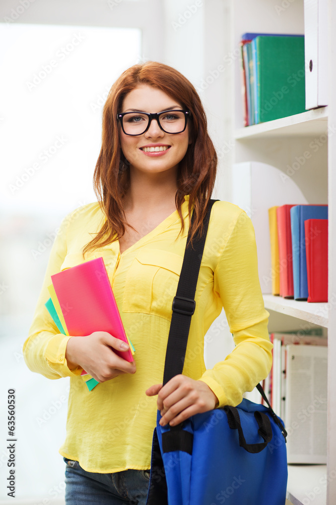 smiling female student with bag and notebooks smiling female student with bag and notebooks