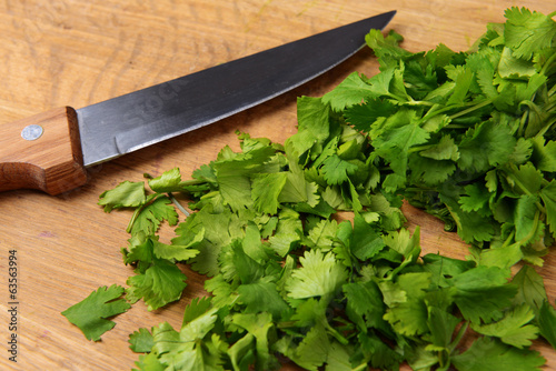 Chopped cilantro on wooden board close-up