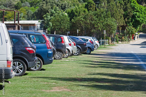 Obraz na plátně Cars parked in a parking lot on the grass.