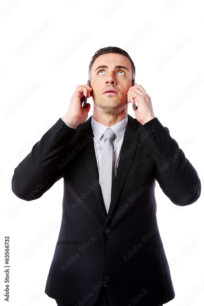 Businessman talking on two cell phones at the same time