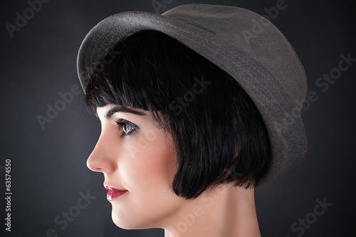 profile of a face of a beautiful woman in a male hat