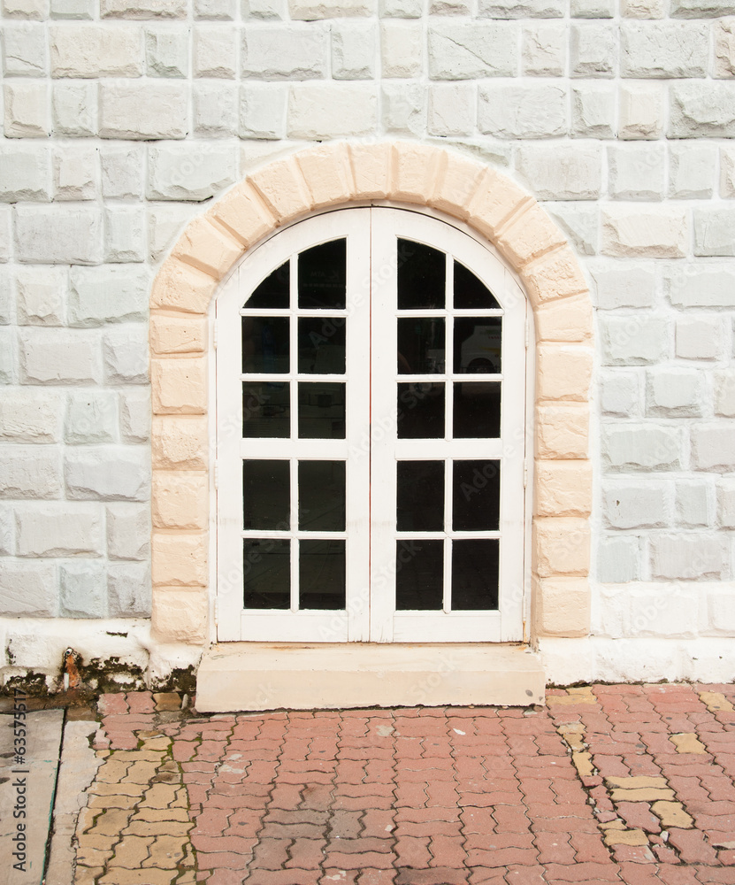 old brick and stone wall with door to the house