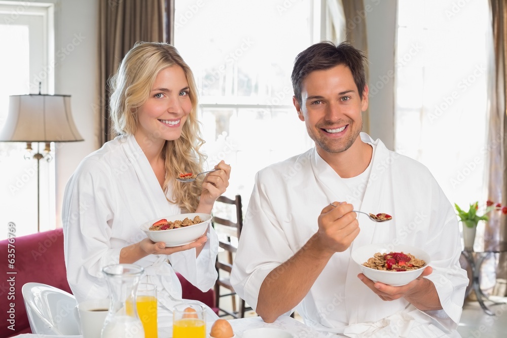 Happy young couple having breakfast at home