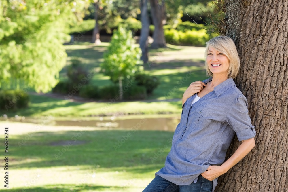 Beautiful woman leaning on tree trunk Beautiful woman leaning on tree trunk