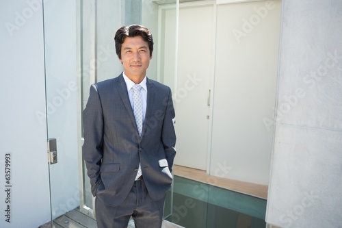 Confident estate agent standing at front door