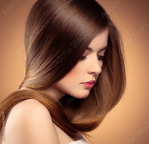 Tender woman with perfect shiny long hair posing in studio