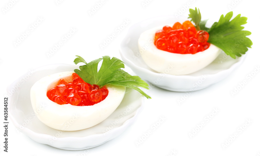 Red caviar in eggs on little white saucers isolated on white Red caviar in eggs on little white saucers isolated on white