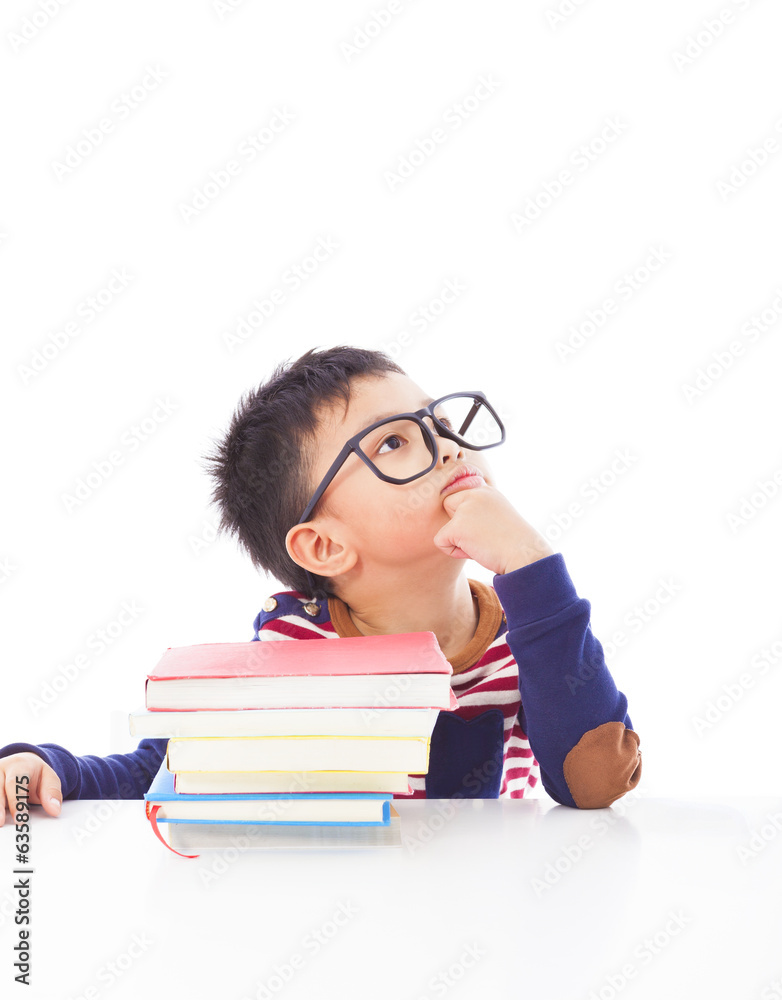 little boy thinking or dreaming during preparing homework little boy thinking or dreaming during preparing homework