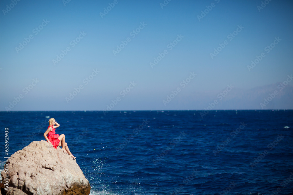 girl on the rock in the sea