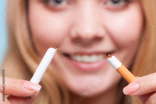 Addiction. Girl breaking cigarette. Quit smoking. photo