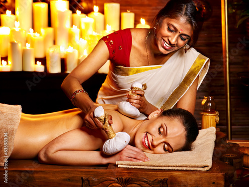 Woman having massage with pouch of rice.