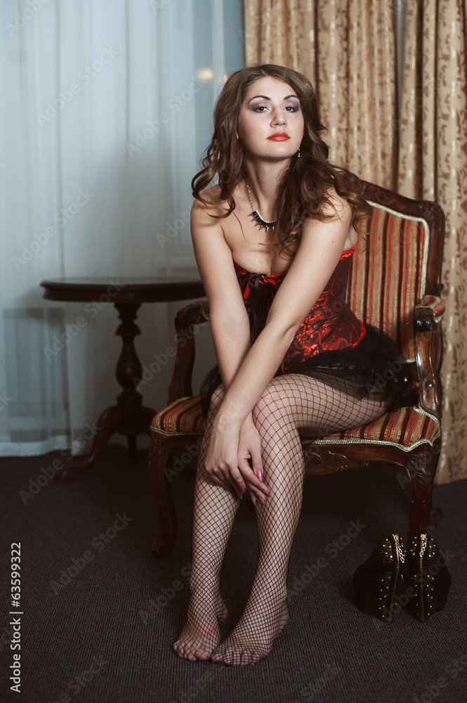 Naklejka premium Beautiful sexy woman sitting on chair
