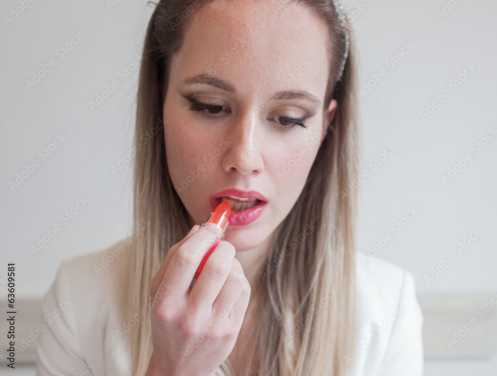 Attractive young woman in the restaurant holding lipstick Attractive young woman in the restaurant holding lipstick