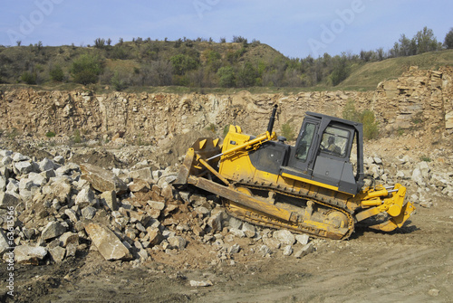 A picture of a big yellow bulldozer at work-site