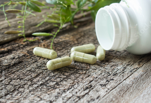 Obraz na plátně Herb capsule on old wood