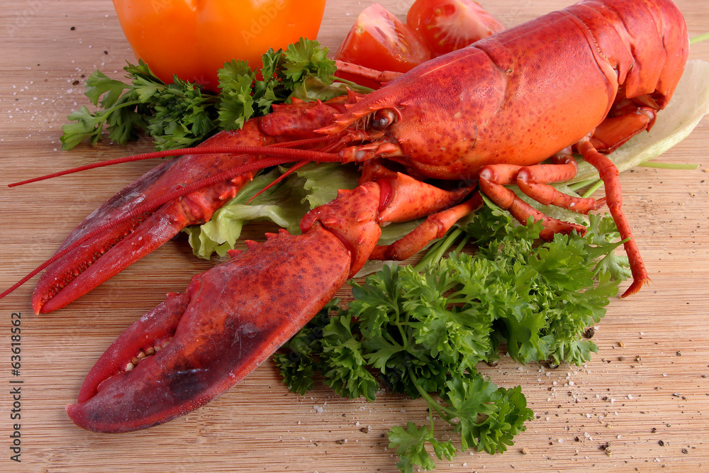 Cooked lobster with various vegetables on wooden board Cooked lobster with various vegetables on wooden board
