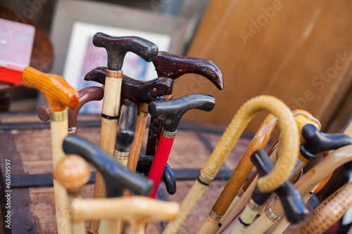 Assorted canes and walking sticks in a wooden holder photo