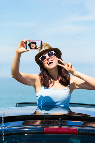 Woman taking selfie photo on car summer vacation