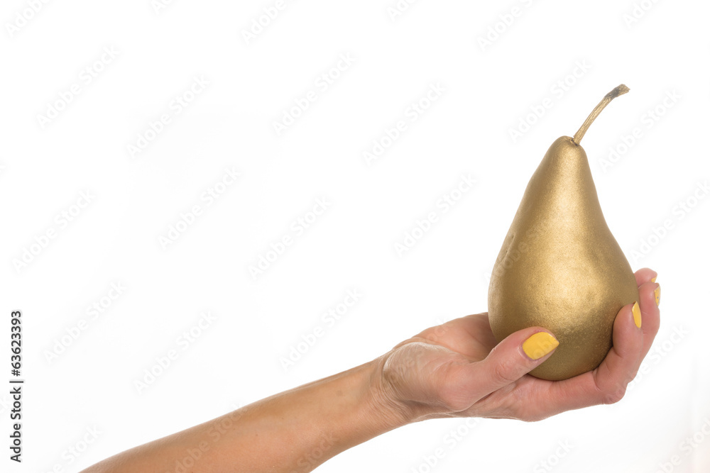 Female hand holding a golden pear, on white Female hand holding a golden pear, on white
