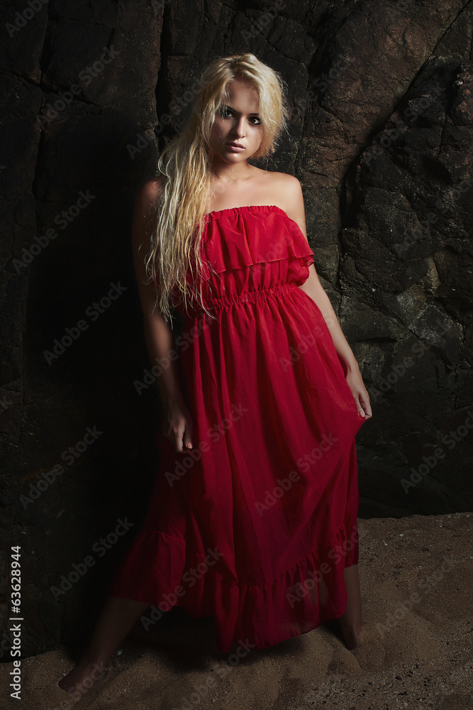 Beautiful blond woman in Red Dress.near the rock.Summer Beautiful blond woman in Red Dress.near the rock.Summer