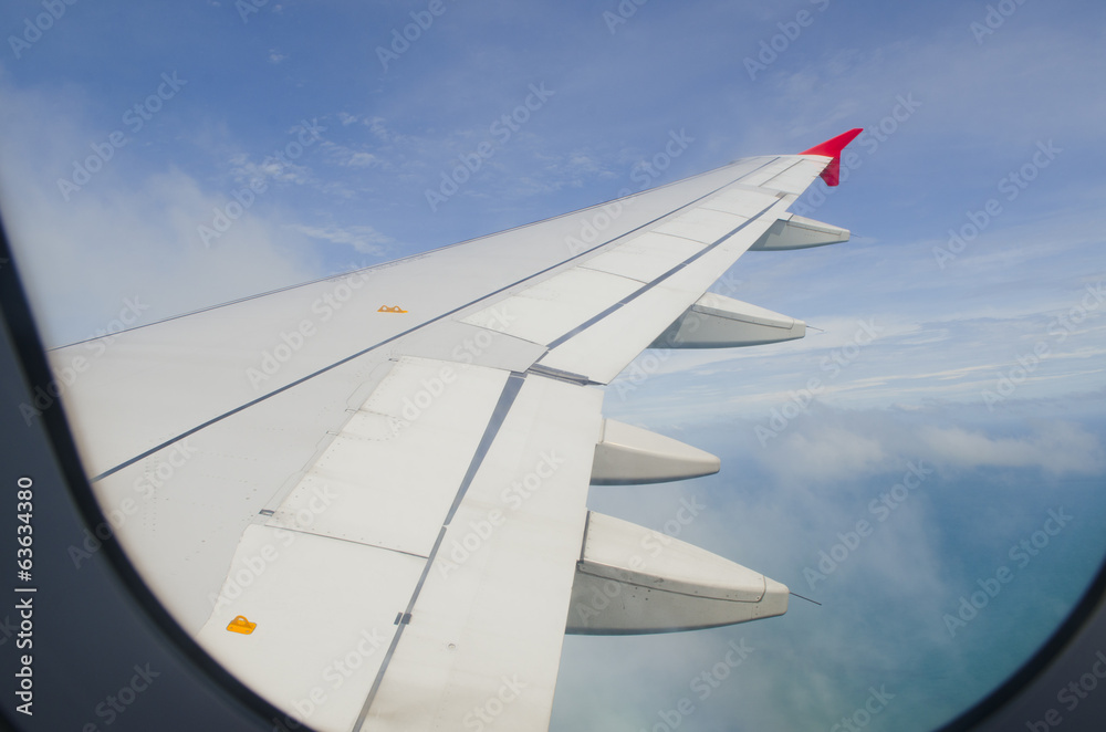 Airplane wing in the blue sky with white clouds Airplane wing in the blue sky with white clouds