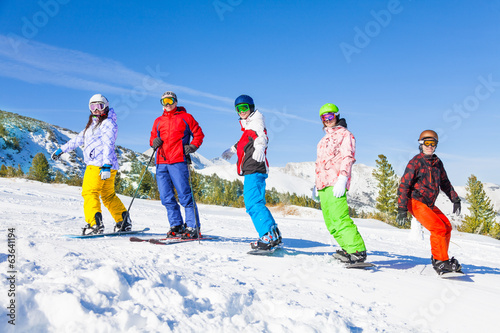 Skier and snowboarders standing in a row