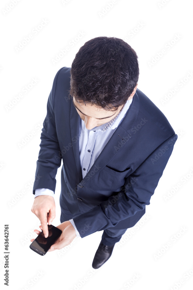 Handsome business man reading an SMS on smartphone against white Handsome business man reading an SMS on smartphone against white
