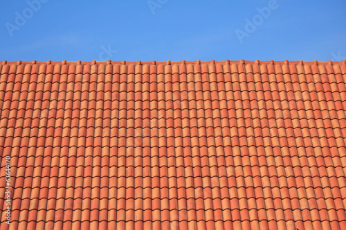 dark brown roof against blue sky © singkamc