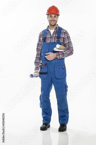 a craftsman in workwear clothing with an hardhat and blueprints