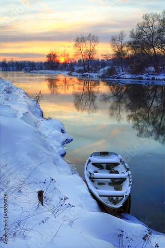Winter sunset on the river with a boat