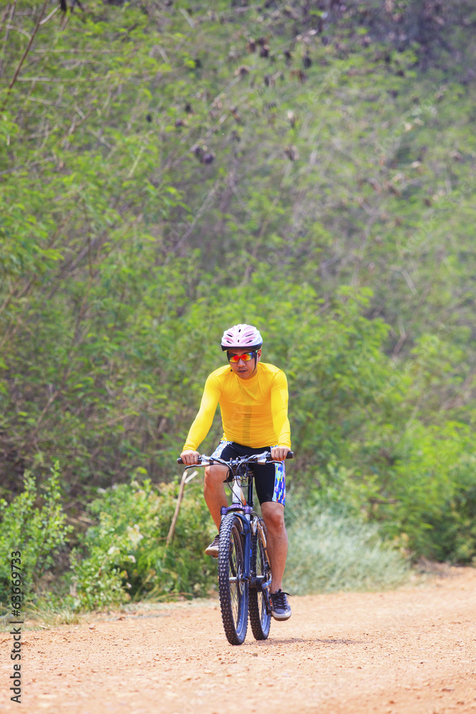 young man riding mountain bike in dusty road use for sport leisu