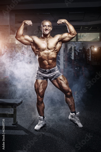 Bodybuilder man posing in the gym