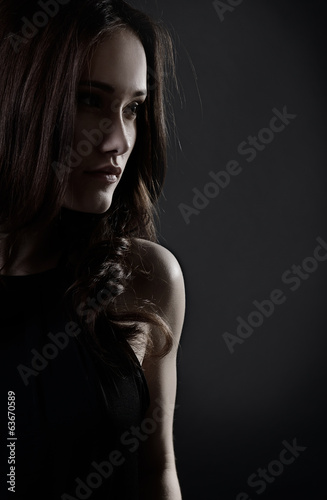 Young woman with beautiful long brown hair posing at studio, pro