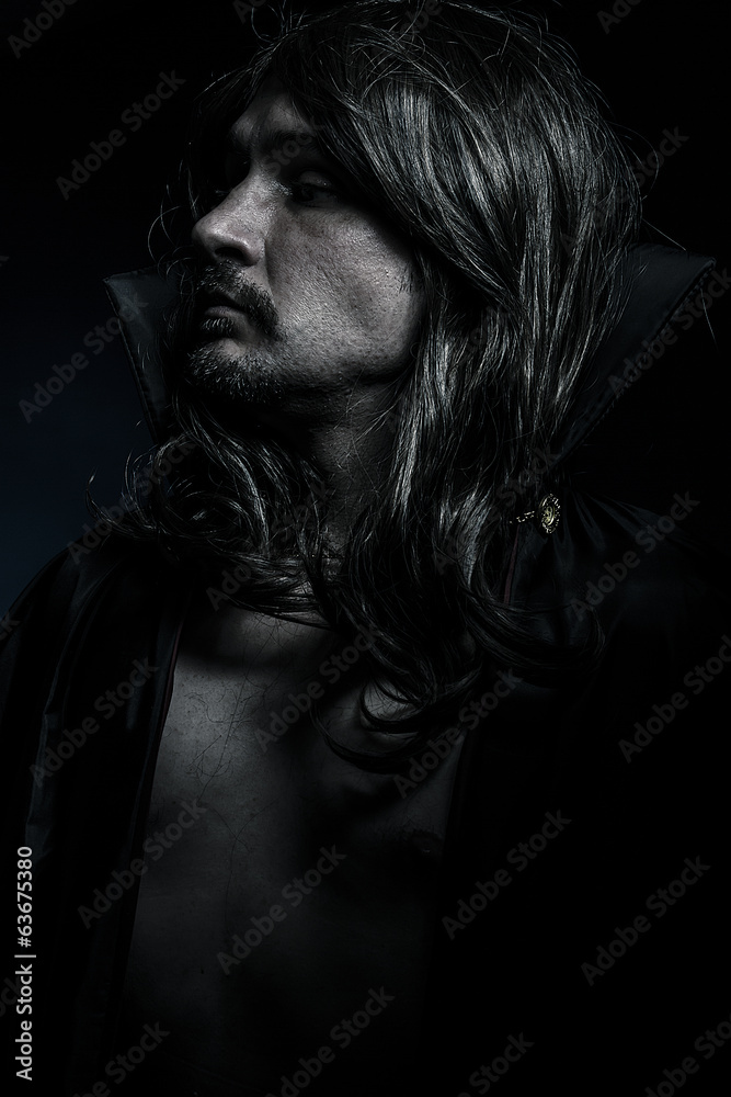 Vampire with black coat and long hair, blue light
