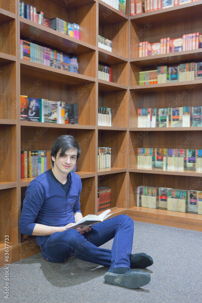 young student reading a book at the library young student reading a book at the library