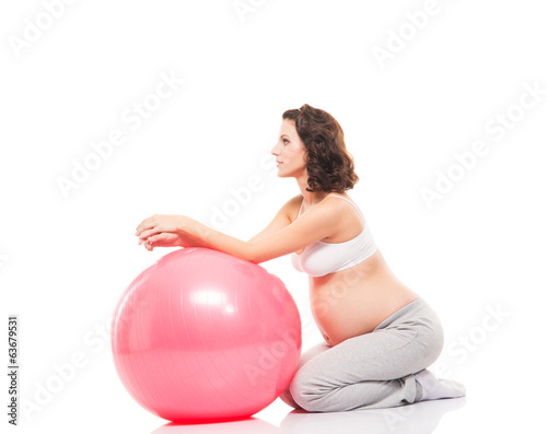 Pregnant woman training with a fitness ball isolated on white © Acronym