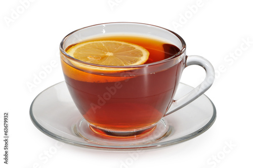 Glass cup with tea and a lemon on a glass saucer
