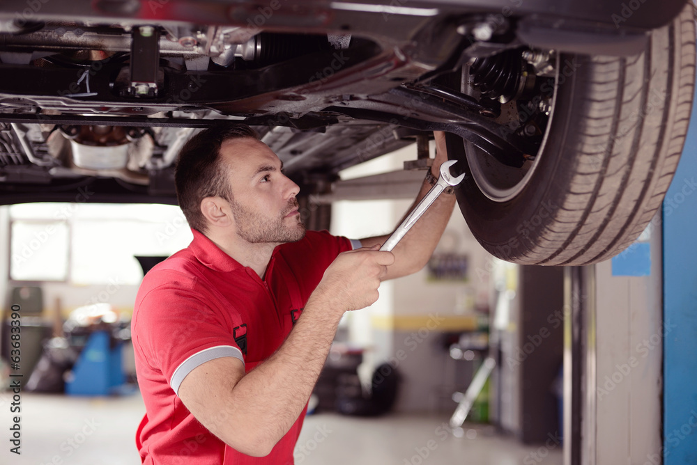 Mechanic with tool checking car Mechanic with tool checking car