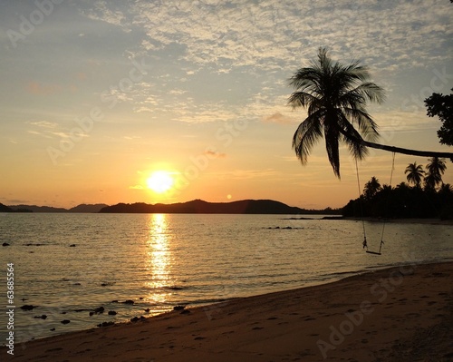 tropical sunset with coconut tree on the sand beach