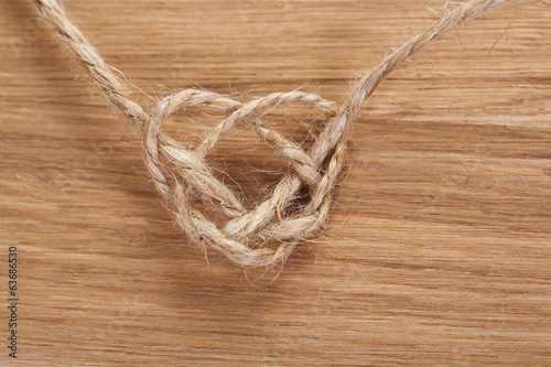 Heart shape from rope, on wooden background