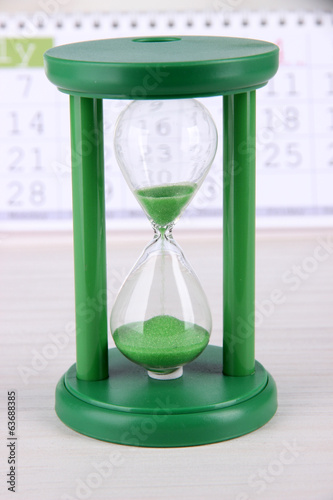 Hourglass and calendar close-up