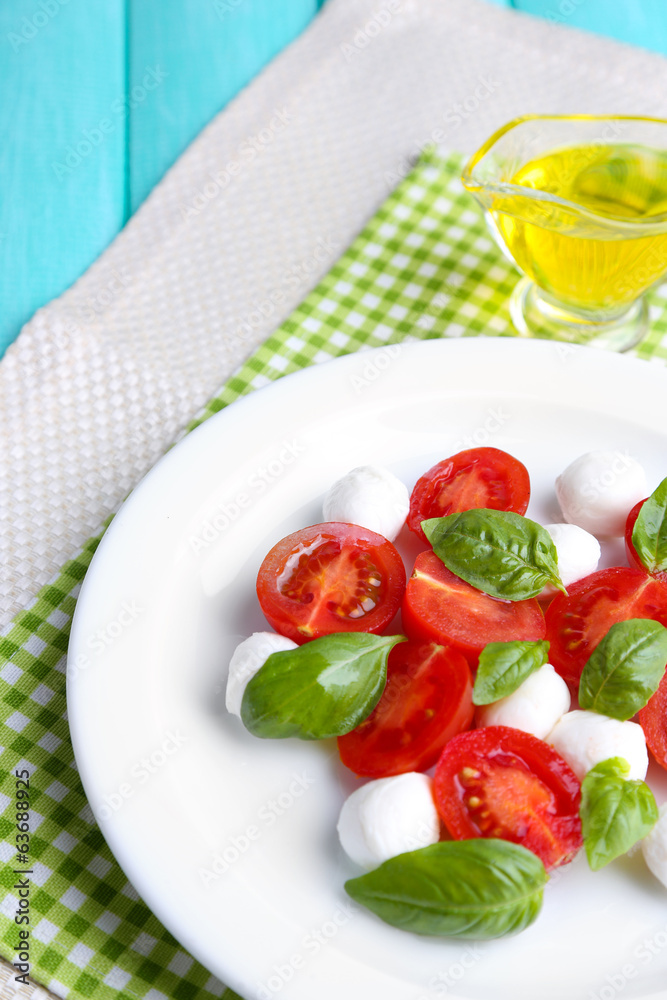 Caprese salad with mozarella cheese, tomatoes and basil