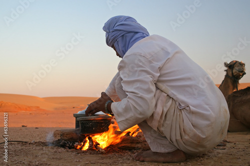 Native arab bedouin making a dinner in the desert photo