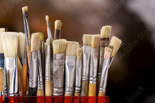 Artist's brushes in front of a colorful background