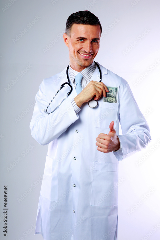 Happy male doctor lays down in his pocket money