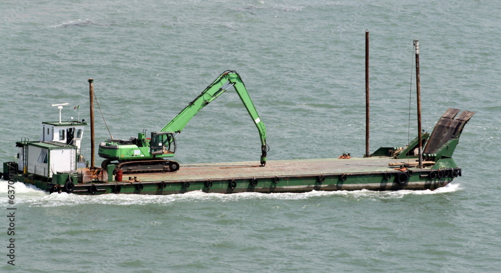 transport boat with a heavy bulldozer over heads to the shipyard transport boat with a heavy bulldozer over heads to the shipyard